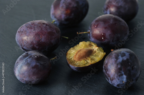 ripe plums on a black background