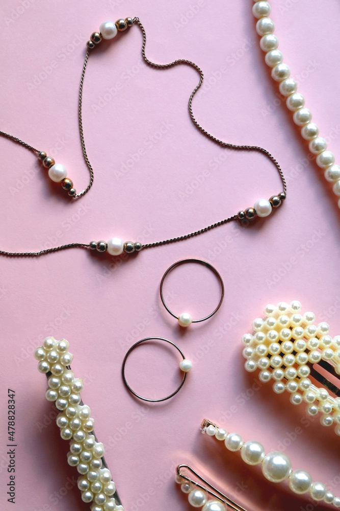 Various pearl jewelry and hair accessories on pink background. Flat lay. Various pearl jewelry and hair accessories on pink background. Flat lay.
