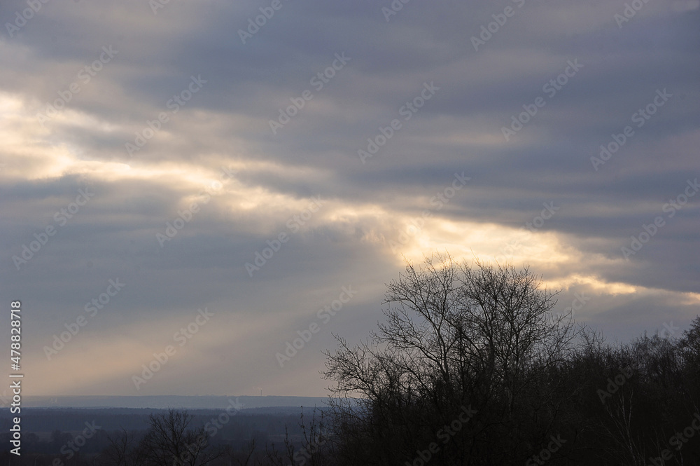 Fototapeta premium dramatic lighting - the rays of the sun break through the autumn lead clouds