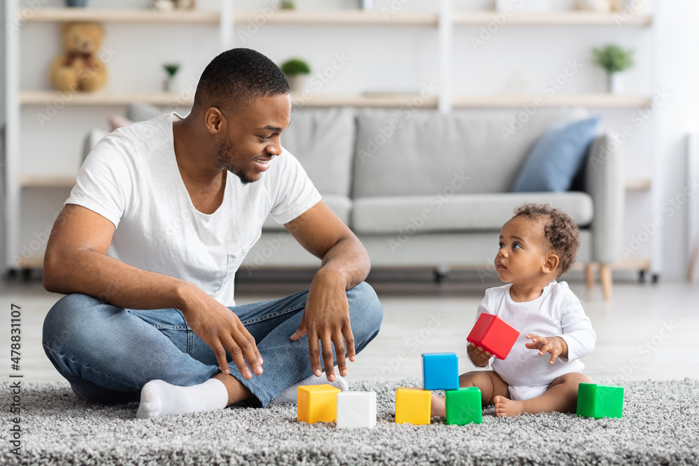 Black Father And His Infant Baby Playing With Building Blocks At Home Black Father And His Infant Baby Playing With Building Blocks At Home