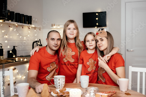 A family in red T-shirts celebrating Christmas in the kitchen