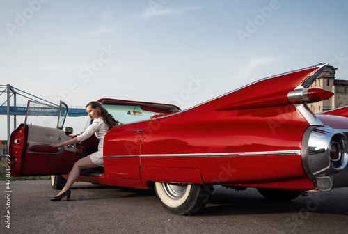 Foto 60-s oldtimer red Cadillac and a beautiful young girl
