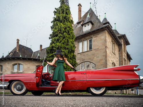 Fotografiet Old-timer red Cadillac and a beautiful young girl
