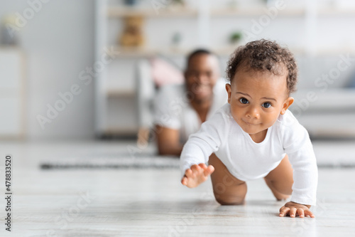 Canvas Print Adorable Black Infant Baby Crawling Away From Father At Home