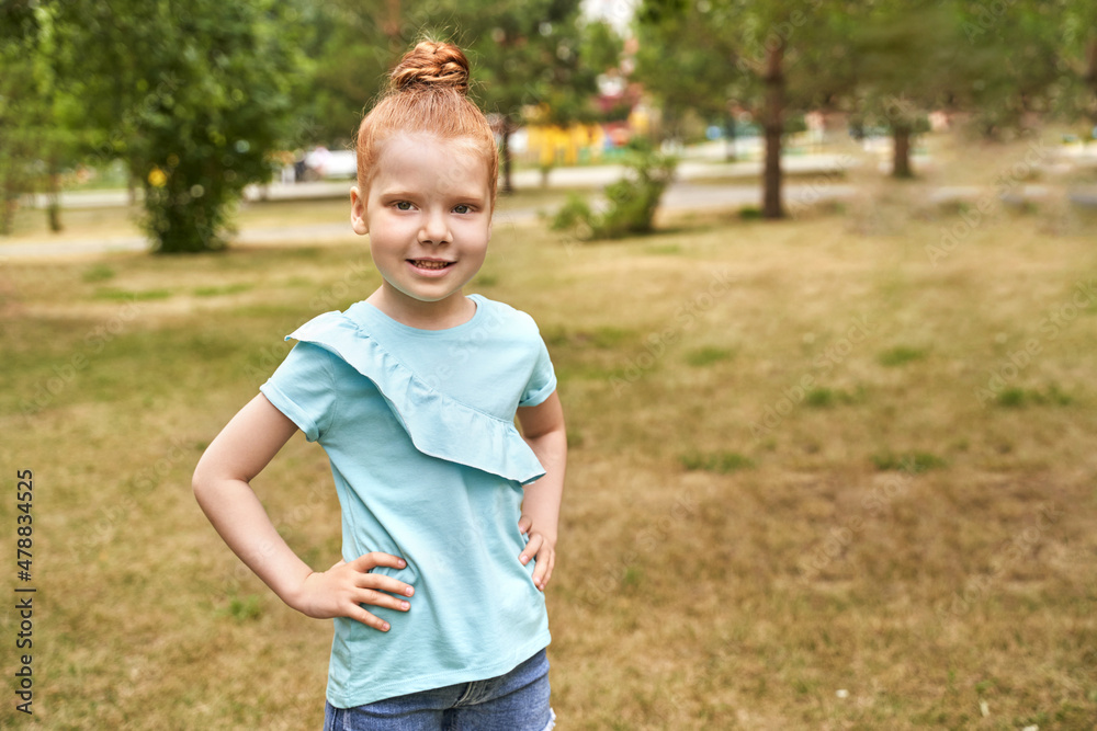 Little girl outdoor portrait. Red hair. Happy baby face. Female person at backyard. American smart schoolgirl. Positive child expression. Smile kid face. Summer time Little girl outdoor portrait. Red hair. Happy baby face. Female person at backyard. American smart schoolgirl. Positive child expression. Smile kid face. Summer time