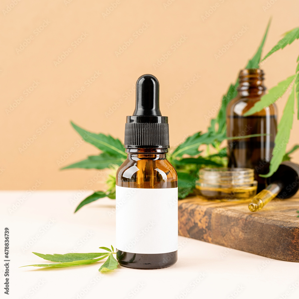 cbd oil and cannabis leaves cosmetics front view on orange background cbd oil and cannabis leaves cosmetics front view on orange background
