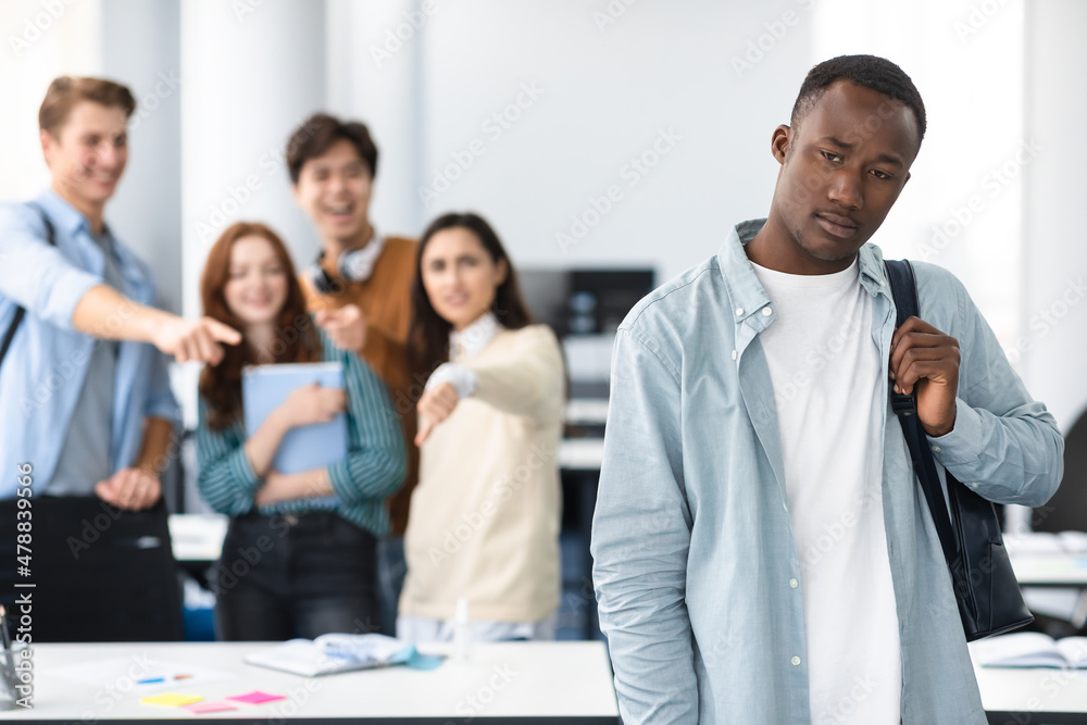People mocking and making fun of sad African man People mocking and making fun of sad African man