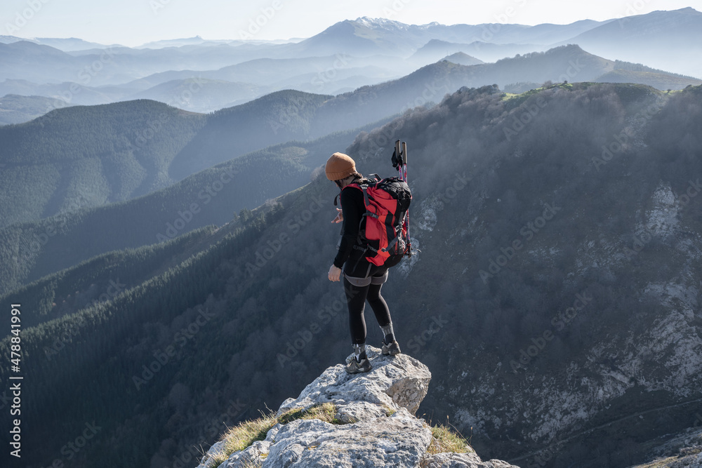 Obraz premium chica en la montaña con una mochila y mar de nubes de fondo
