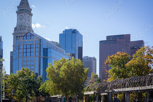City view of Boston with glass buildings and trees in the park. Weaved wooden arched tunnel at front