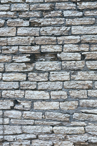 old stone wall made of weathered bricks as background