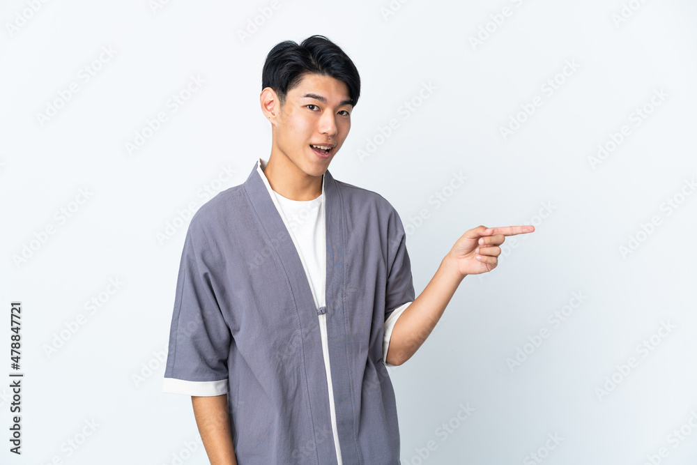 Young Chinese man isolated on white background pointing finger to the side and presenting a product Young Chinese man isolated on white background pointing finger to the side and presenting a product