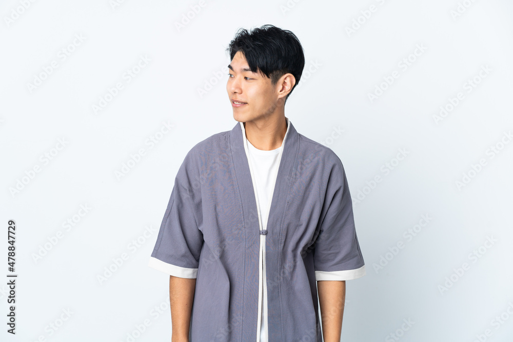 Young Chinese man isolated on white background looking to the side and smiling Young Chinese man isolated on white background looking to the side and smiling