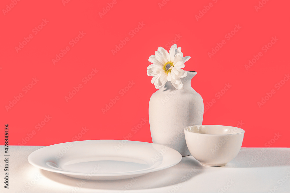 Minimalist still life with vase, chrysanthemum flower, and white dishes isolated on pink background, product stand, kitchenware mock-up Minimalist still life with vase, chrysanthemum flower, and white dishes isolated on pink background, product stand, kitchenware mock-up