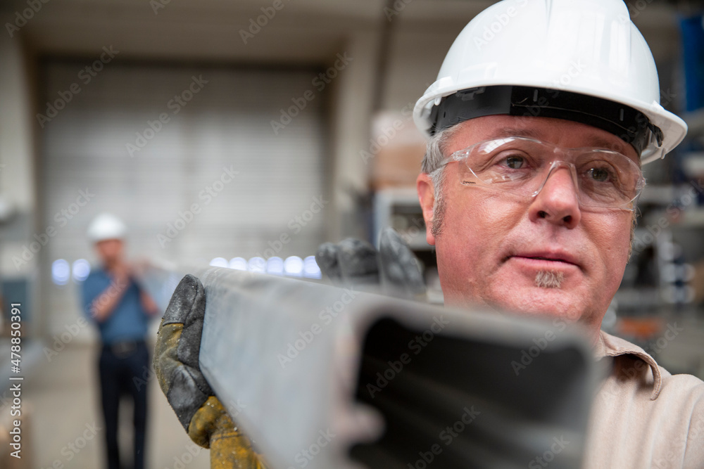 Workers carrying steel beam in manufacturing plant Stock Photo Adobe