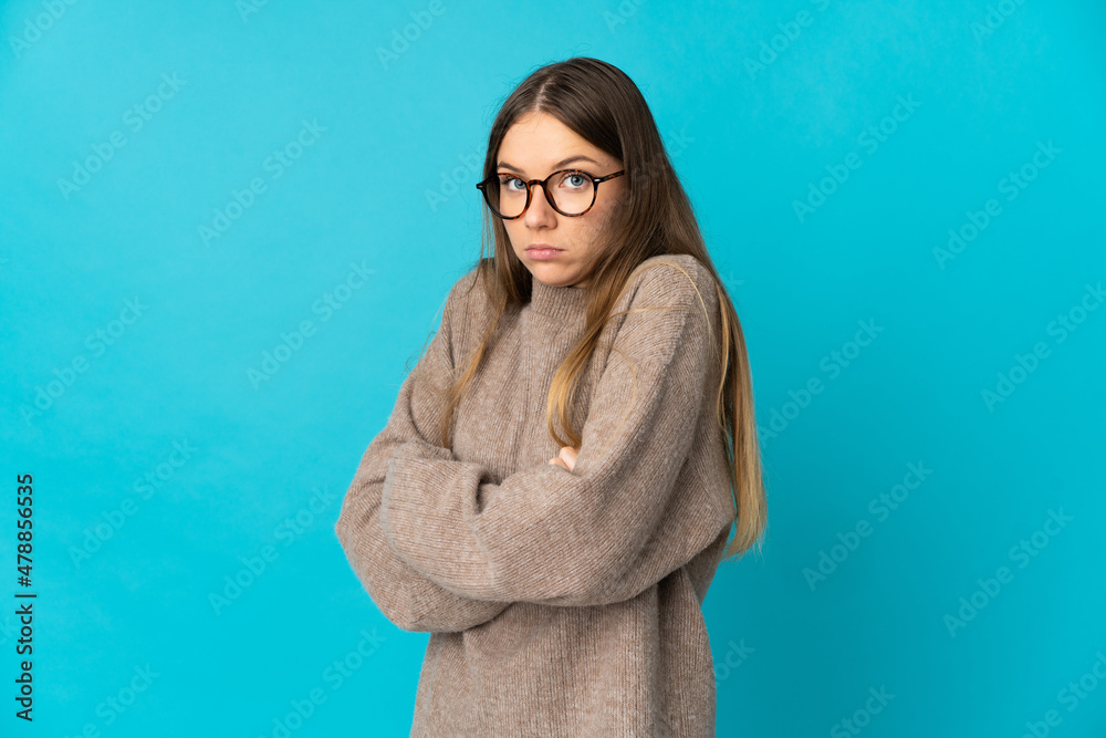 Young Lithuanian woman isolated on blue background making doubts gesture while lifting the shoulders