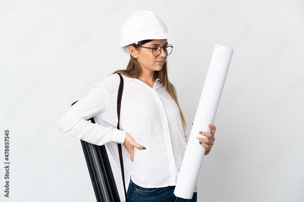 Young Lithuanian architect woman with helmet and holding blueprints isolated on white background suffering from backache for having made an effort Young Lithuanian architect woman with helmet and holding blueprints isolated on white background suffering from backache for having made an effort