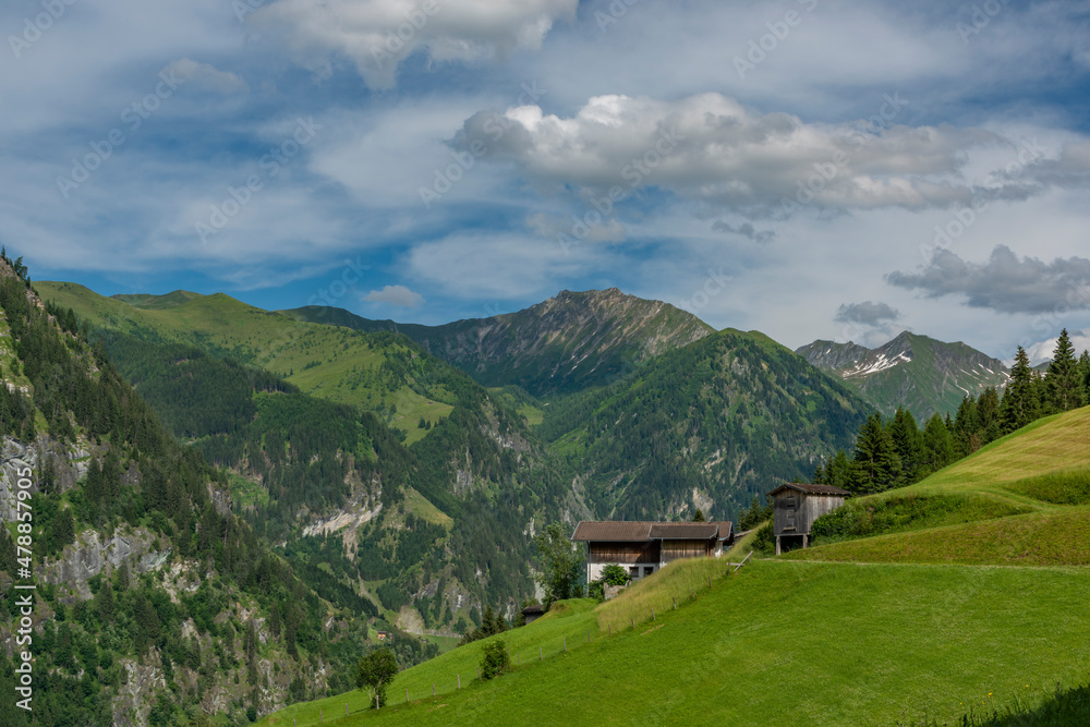 Summer valley with Grossarler Ache small river and blue cloudy sky