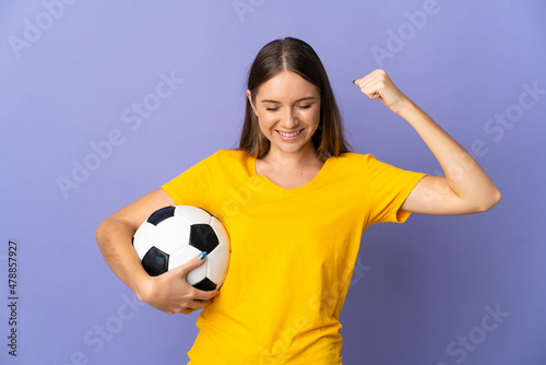 Young Lithuanian football player woman isolated on purple background doing strong gesture © luismolinero