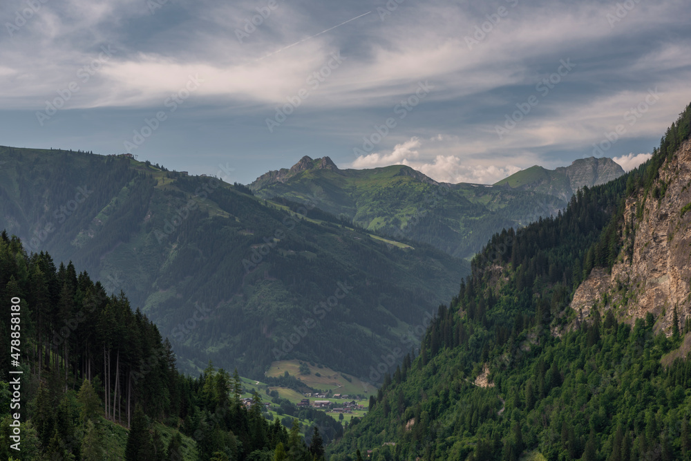 Summer valley with Grossarler Ache small river and blue cloudy sky