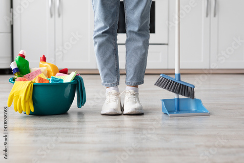 Unrecognizable male or female in casual outfit cleaning apartment