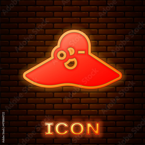 Glowing neon Elegant women hat icon isolated on brick wall background. Vector