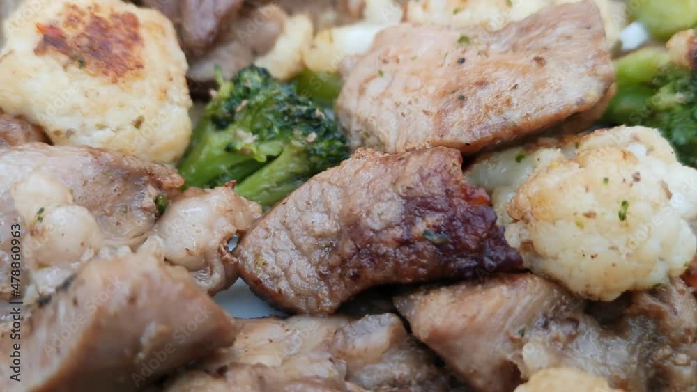 Meat with broccoli and cauliflower. Fried meat with vegetables. Close-up, rotation. Meat with broccoli and cauliflower. Fried meat with vegetables. Close-up, rotation.