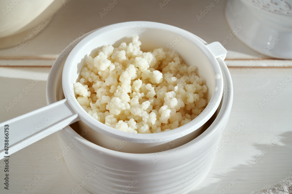 Fresh kefir grains in a white sieve Fresh kefir grains in a white sieve