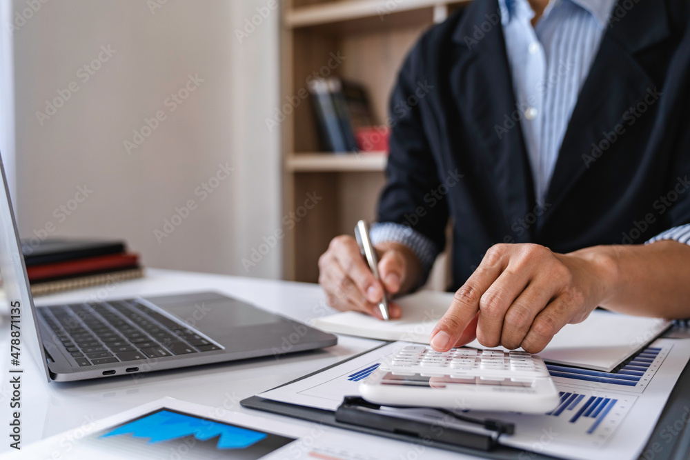 Close-up calculator  to calculate the company's financial results On the wooden table in the office and business work background, tax, accounting, statistics, and analytical research concept