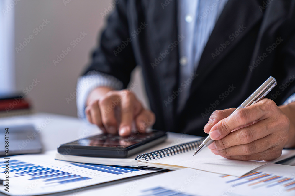 Close-up calculator to calculate the company's financial results On the wooden table in the office and business work background, tax, accounting, statistics, and analytical research concept Close-up calculator to calculate the company's financial results On the wooden table in the office and business work background, tax, accounting, statistics, and analytical research concept