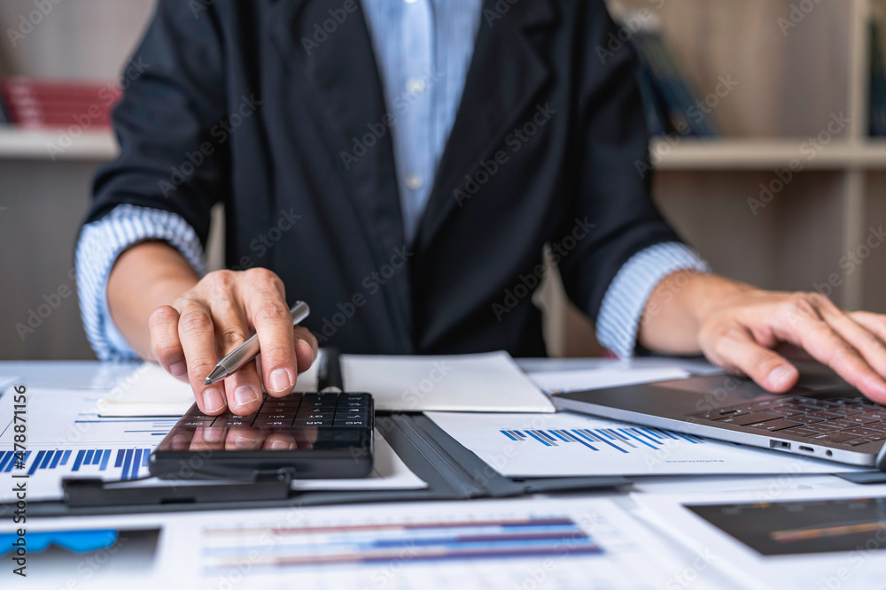 Close-up calculator  to calculate the company's financial results On the wooden table in the office and business work background, tax, accounting, statistics, and analytical research concept