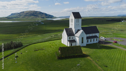 Magnificent Lutheran church or cathedral in Skalholt area of Iceland on a warm summer day.  Majestic church in the middle of green fields and plains. photo
