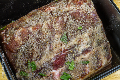 Canvas Print Pork loin or back joint in dry salt cure  becoming bacon with liquid, close up
