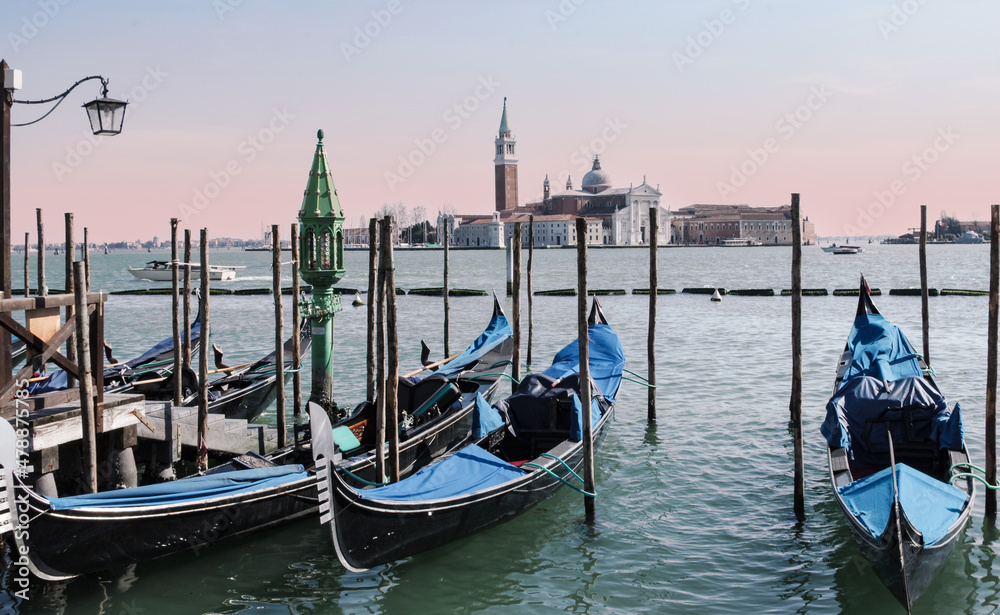 gondolas moored to the Grand Canal, in the background Santa Maria della Salute basilica.Venice, Italy