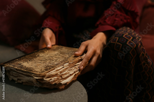 Beautiful woman with old book at home, closeup