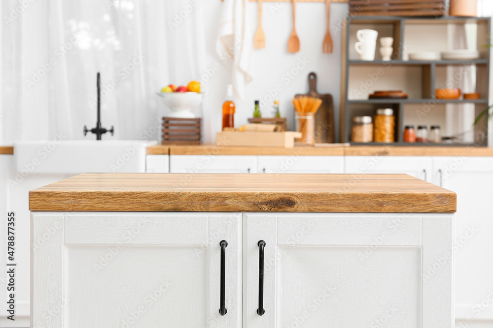 White counter with wooden table top in light kitchen White counter with wooden table top in light kitchen