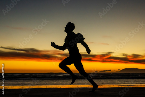 Fototapeta Naklejka Na Ścianę i Meble -  Running on the beach jogging exercise active sprinting selective focus beach background