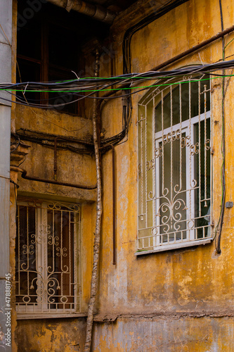 A corner of old building facade of typical houses in Odessacity center old town yards. Huge vintage windows  dirty scratched walls.