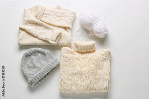 Stylish children's clothes and ball of knitting yarn on white background