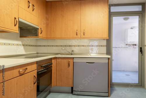 Kitchen furnished with cherry-colored furniture and access to a terrace