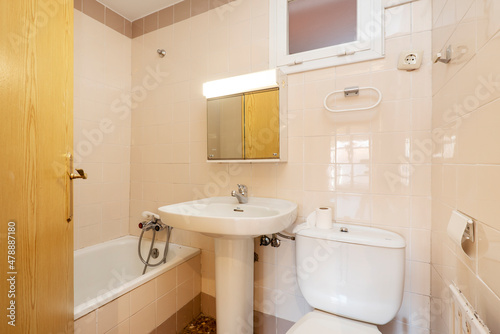 Conventional toilet with white accessories and cream walls