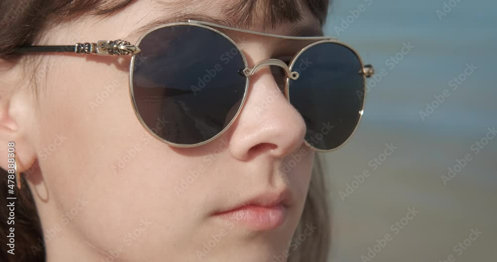 Teen vacation under the sun. A teen enjoy the sea view in sunglasses on the summer beach. Teen vacation under the sun. A teen enjoy the sea view in sunglasses on the summer beach.