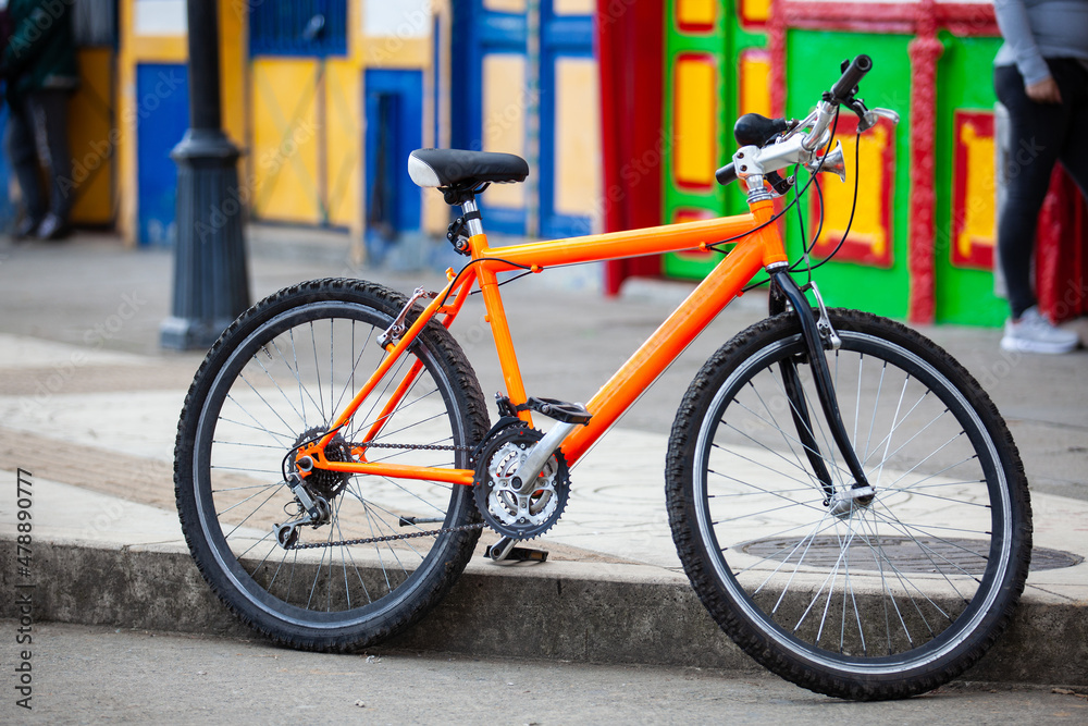 Orange bicycle parked at the colorful streets of of the small town of Salento located at the region of Quindio in Colombia