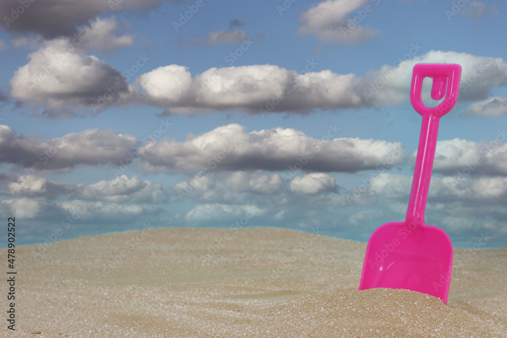 Toy Shovel on Sandy Beach With Blue Sky Toy Shovel on Sandy Beach With Blue Sky