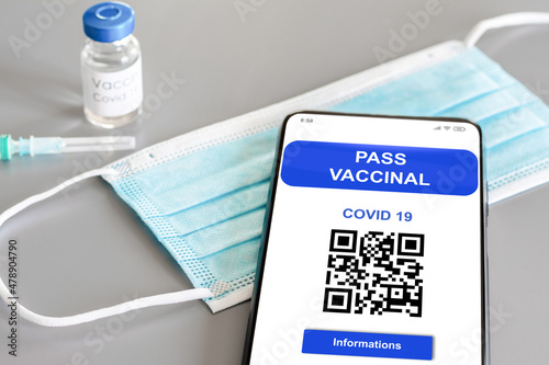 Passe vaccinal Covid 19. Téléphone portable, masque, flacon de vaccin et seringue.