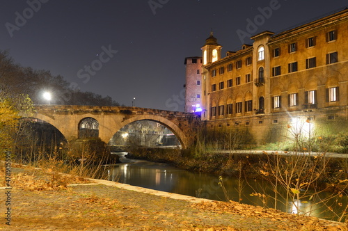 The night view Ponte Fabricio on the Tiber Island and Fate Bene Fratelli Hospital in Rome, Italy.