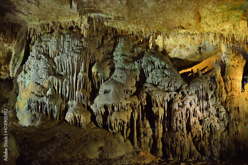 Prometheus cave formations in Georgia. Limestone stalactites and stalagmites in colourful illumination. Underground world of caucasian mountains