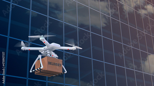 An unmanned quadcopter delivery a box of goods against the backdrop of the glass facade of the building. Contactless logistics during the Covid 19 coronavirus pandemic