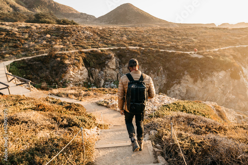 A man walking down a set of stair towards the coast in Big Sur, California