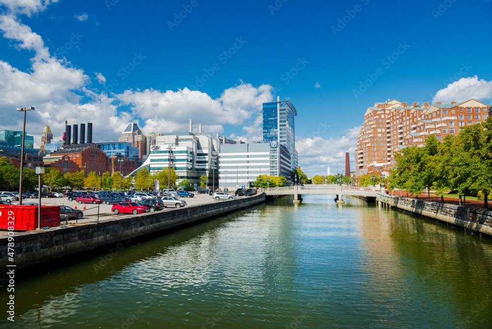 Baltimore East Harbor canal with modern high-rises and historic buildings. Clouds and blue sky over the city.