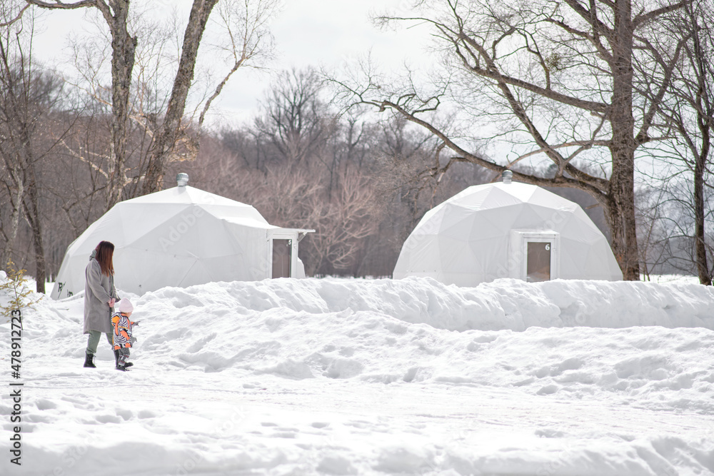 Mom and little daughter are walking through winter glamping. Mom and little daughter are walking through winter glamping.